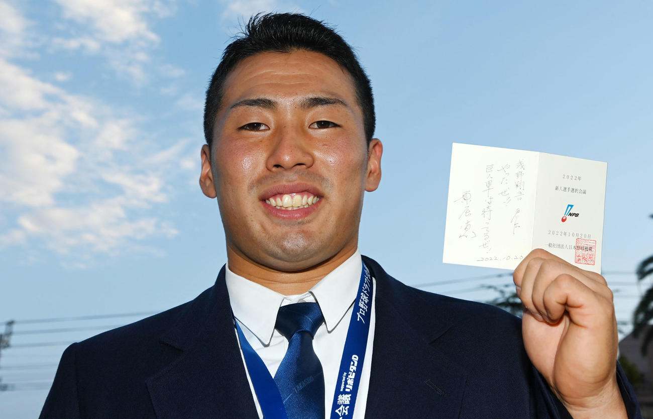 プレゼントされた原監督の直筆メッセージが入った当たりくじを手に笑顔を見せる高松商・浅野（撮影・前岡正明）
