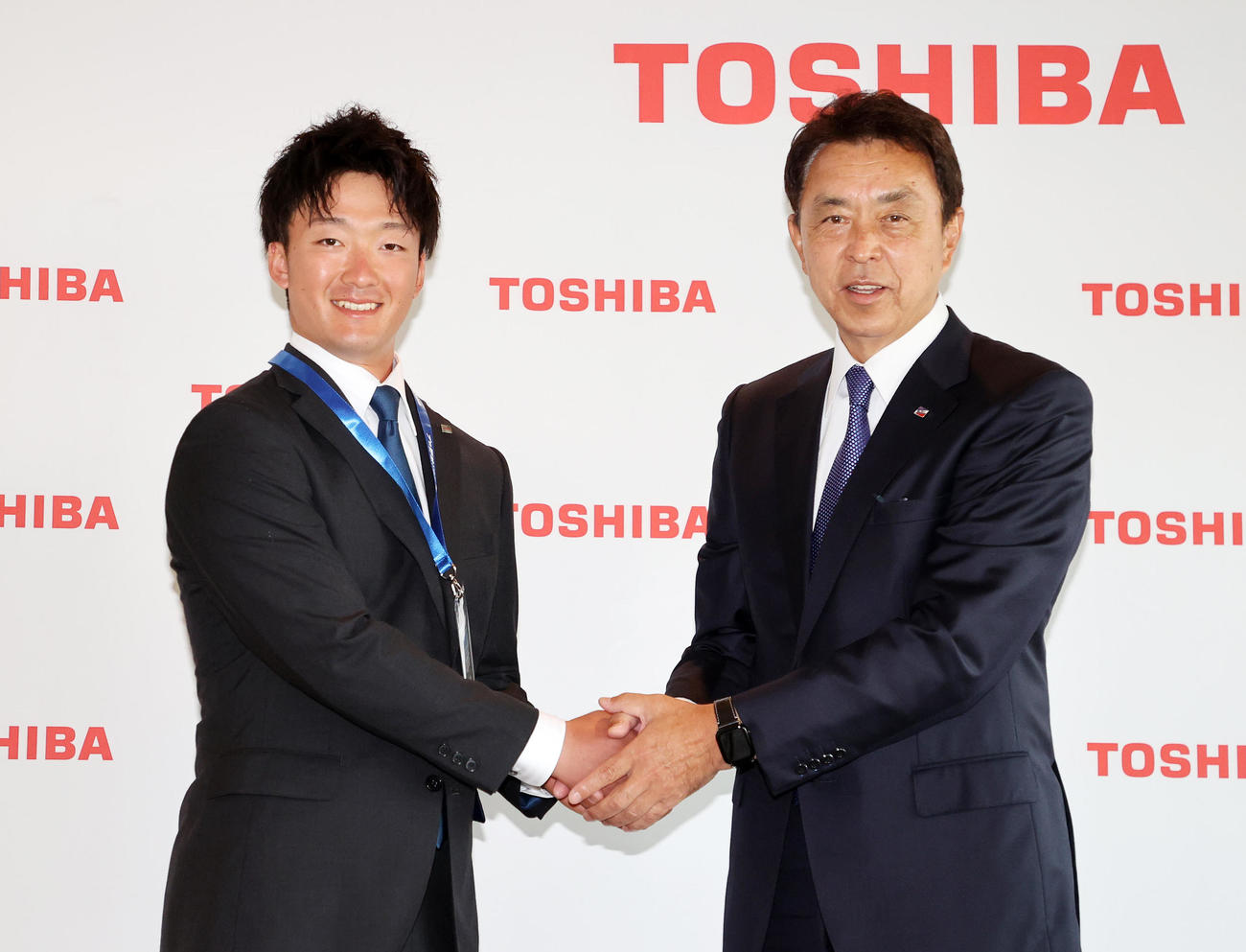 指名あいさつを終え握手する東芝・吉村（左）とヤクルト小川GM（撮影・鈴木正人）