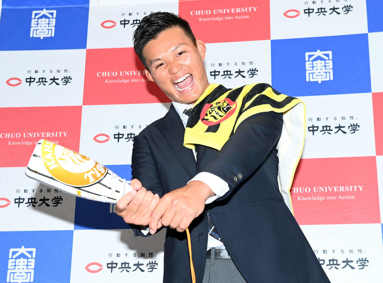 阪神グッズを手にポーズを決める中大・森下（撮影・たえ見朱実）