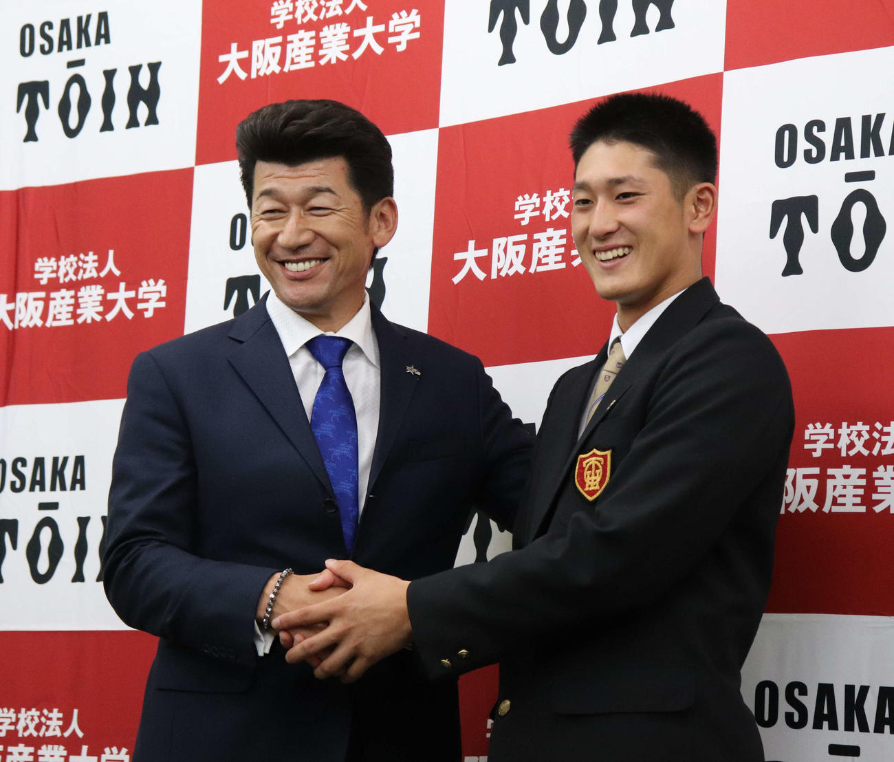 サプライズ訪問したDeNA三浦監督（左）と握手する大阪桐蔭・松尾（撮影・三宅ひとみ）