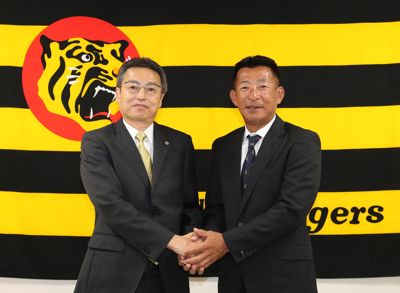 握手を交わす百北球団社長（左）と馬場1軍内野守備走塁コーチ（代表撮影）