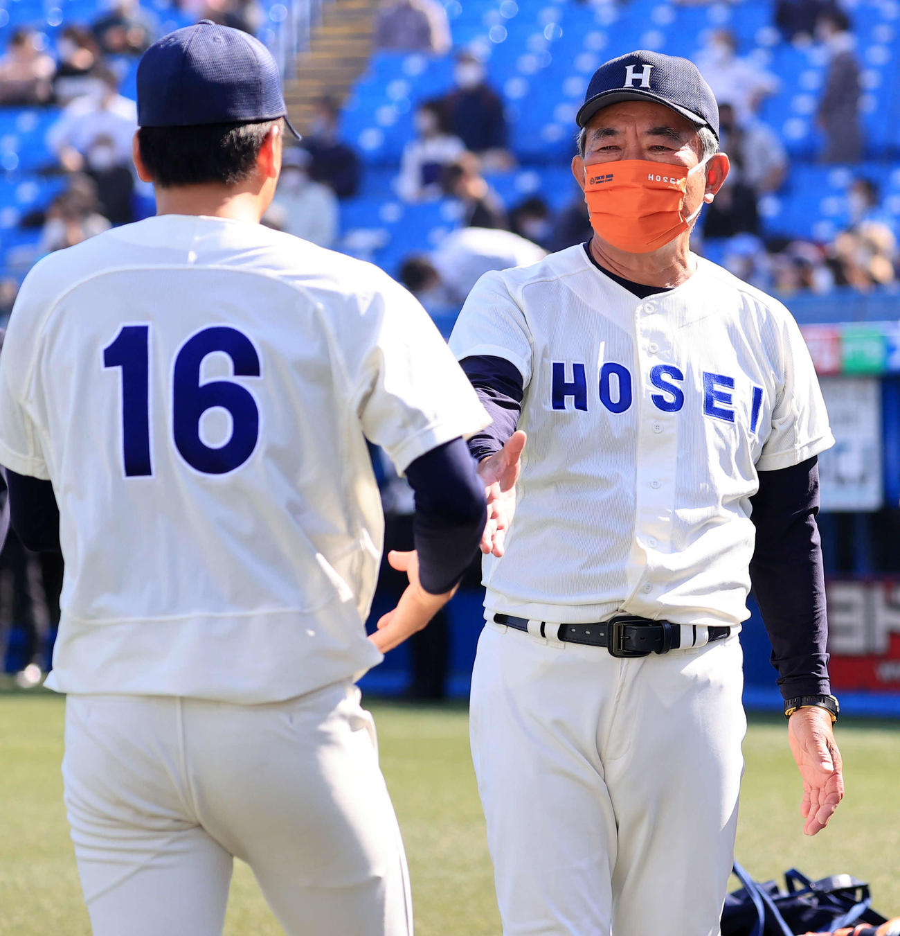 法大対東大　連勝で勝ち点を上げた法大加藤監督（右）は勝利投手の尾崎を握手で迎える（撮影・浅見桂子）