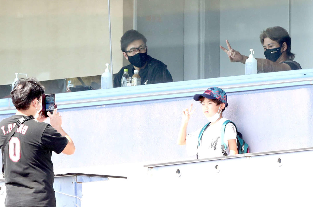 フェニックスリーグ　阪神対ロッテの視察に訪れた日本ハム新庄監督は、観客とVサインで記念撮影する（撮影・黒川智章）