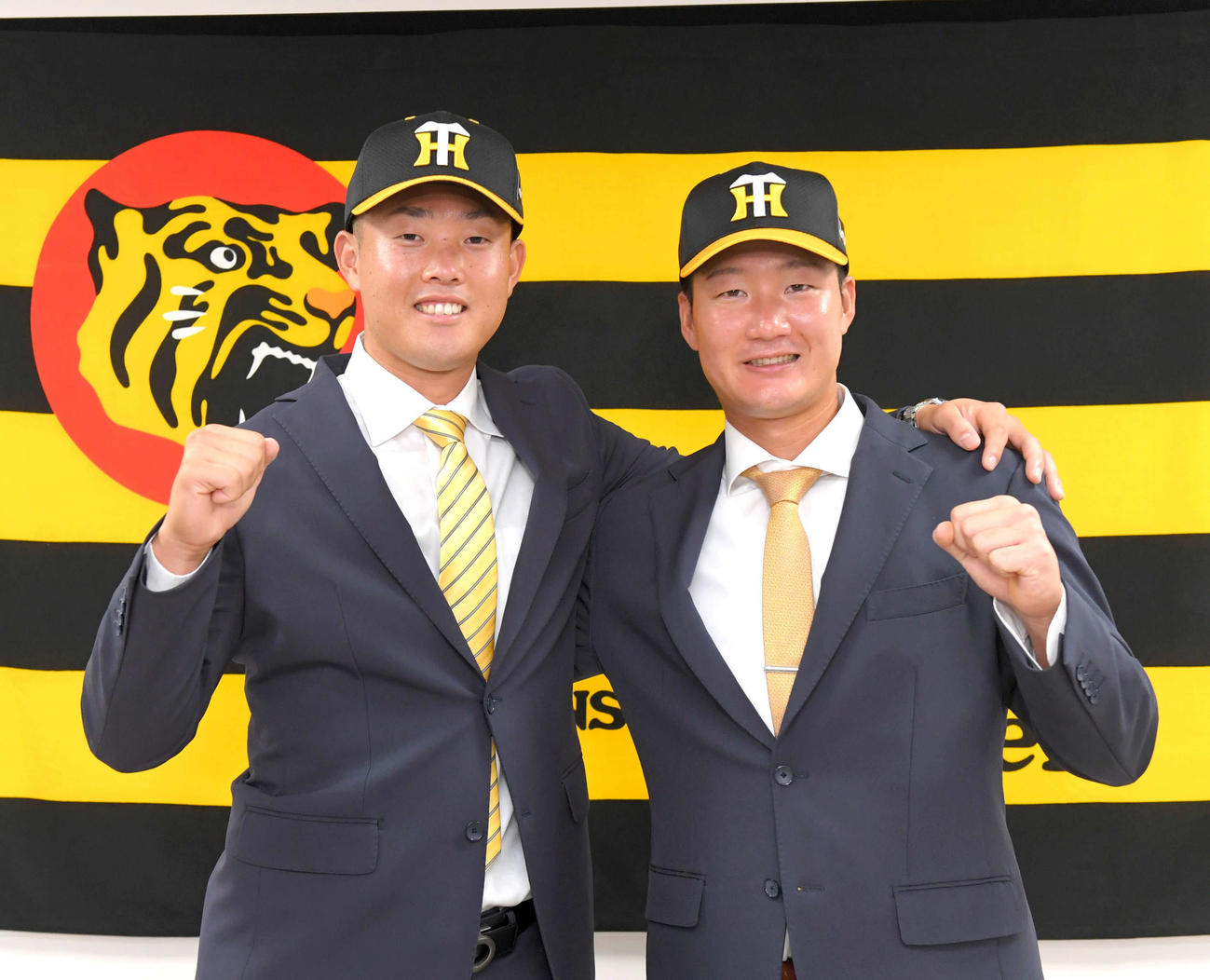 阪神への入団会見でポーズをとる高浜（左）と渡辺諒（代表撮影）