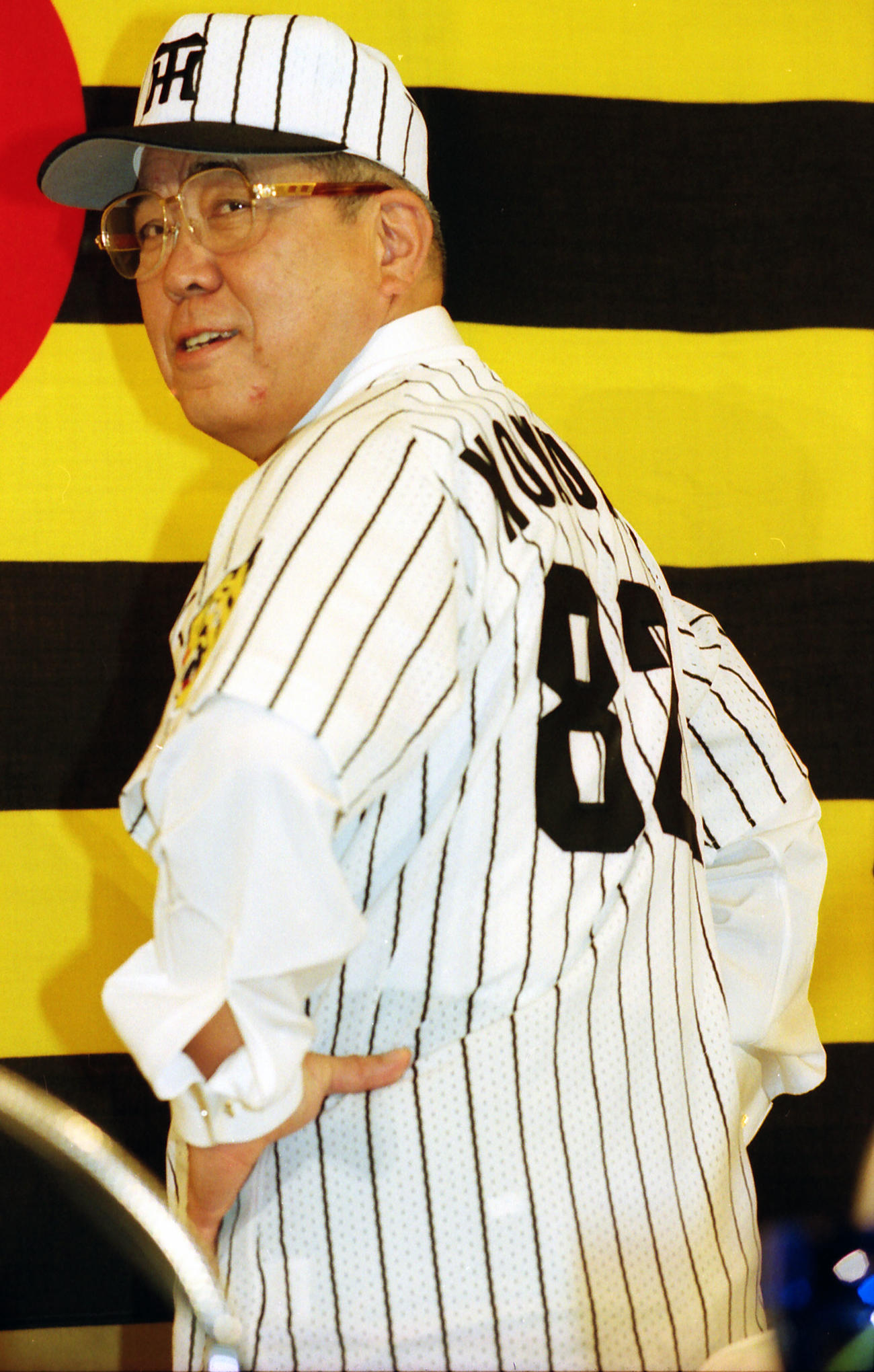 1998年10月28日、入団会見でタイガースのユニホームに袖を通しポーズを決める野村監督