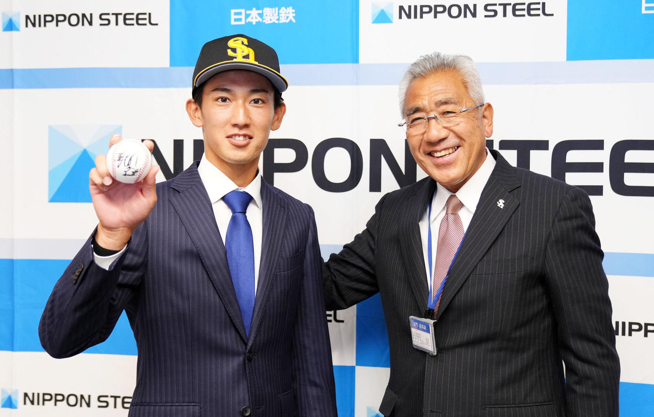 ソフトバンク藤本監督からのサインボールを手に笑顔を見せる日本製鉄鹿島・大津（左）。右は宮田スカウト（撮影・横山健太）