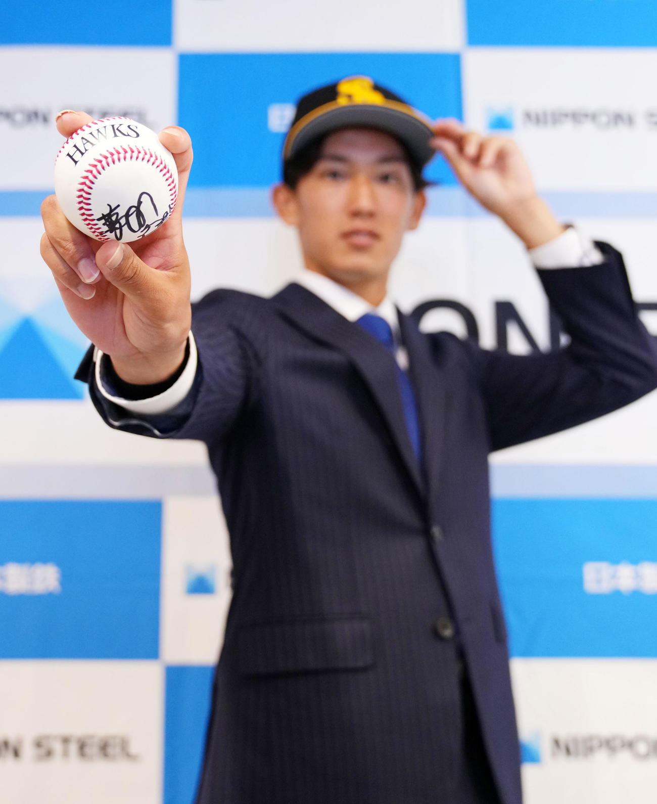 ソフトバンク藤本博史監督からのサインボールを得意のワンシームの握りで持ち笑顔を見せる日本製鉄鹿島・大津（撮影・横山健太）