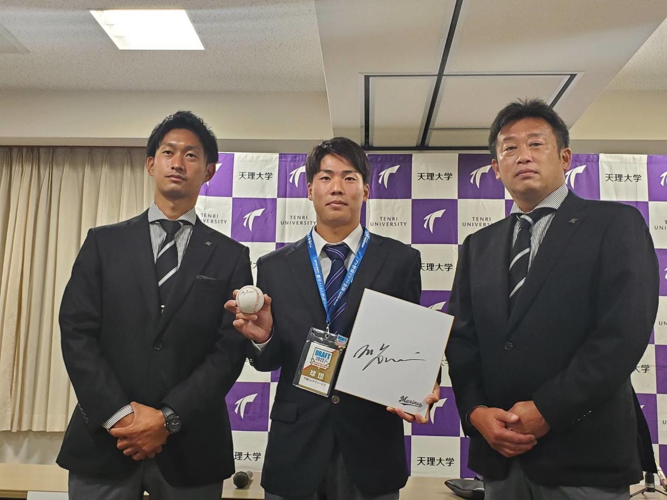 天理大・友杉篤輝内野手は吉井監督のサイン色紙を持ち、三家スカウト（左）と榎スカウト部長の指名あいさつを受けた（撮影：酒井俊作）