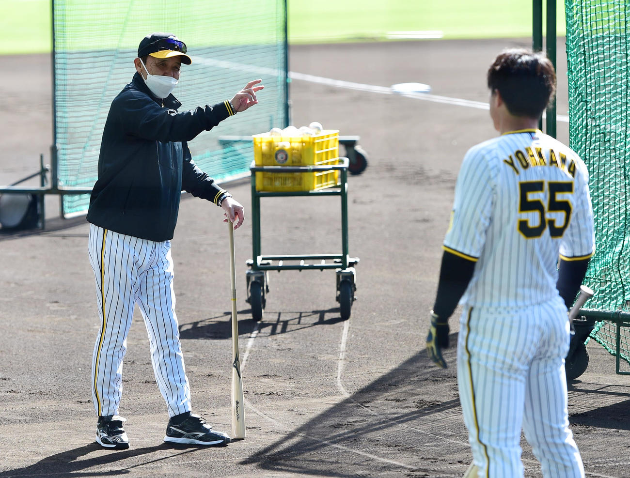 打撃練習で阪神陽川（手前）を指導する岡田監督（撮影・清水貴仁）