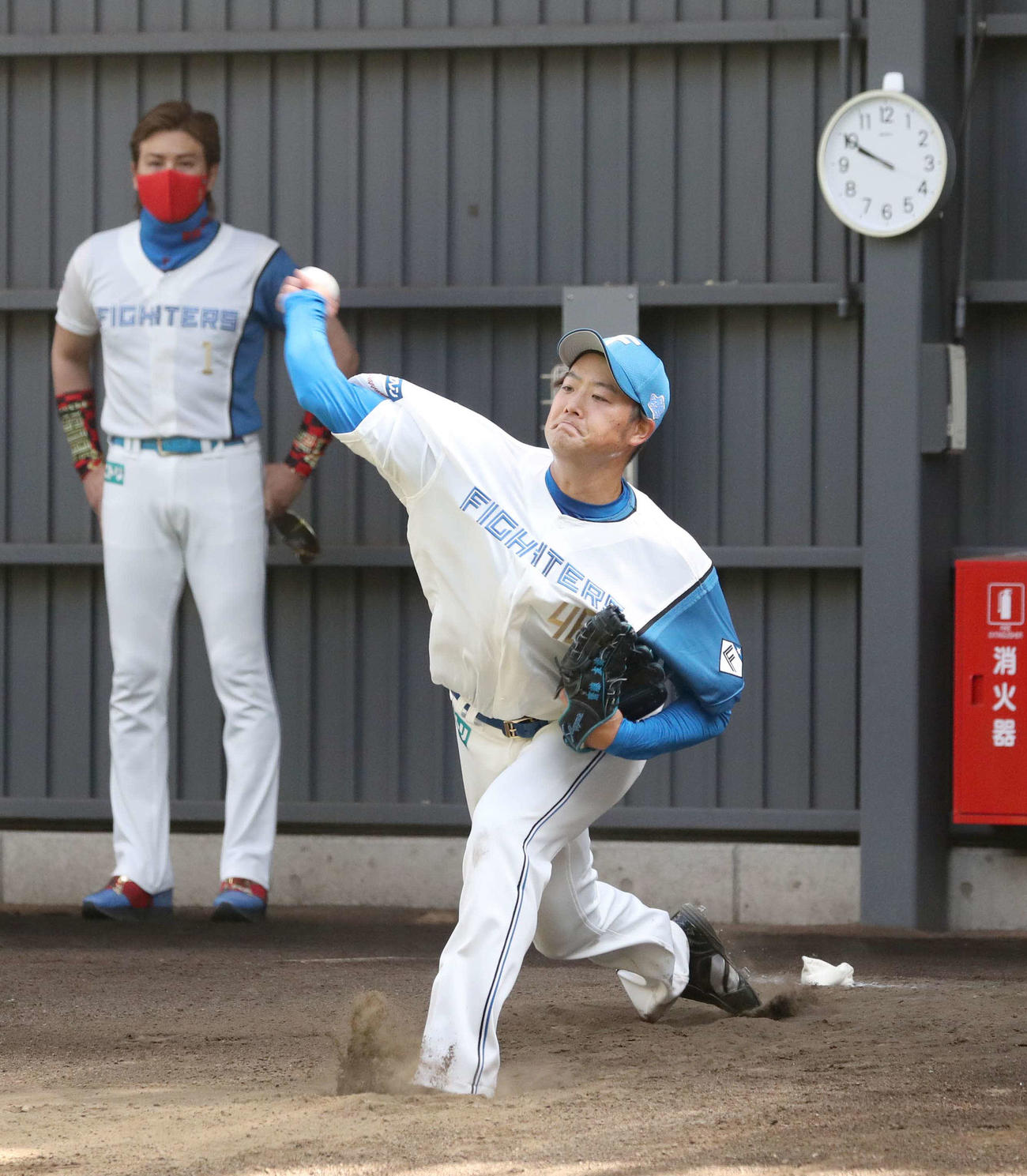 ブルペンで軽く投球する斎藤。後方は新庄監督（撮影・黒川智章）