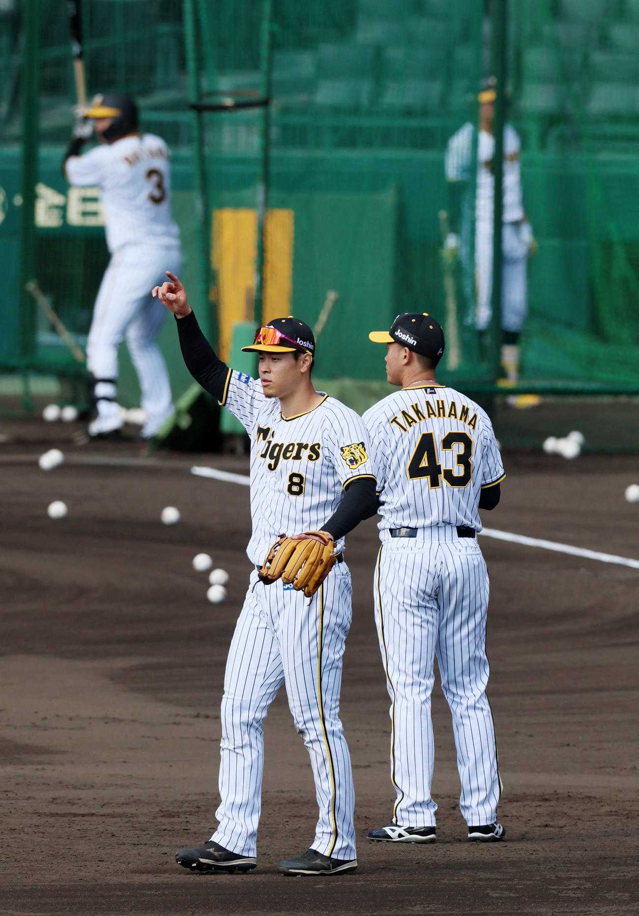 守備練習で外野を指さす佐藤輝。奥は打撃練習中の大山。右は高浜（撮影・加藤哉）