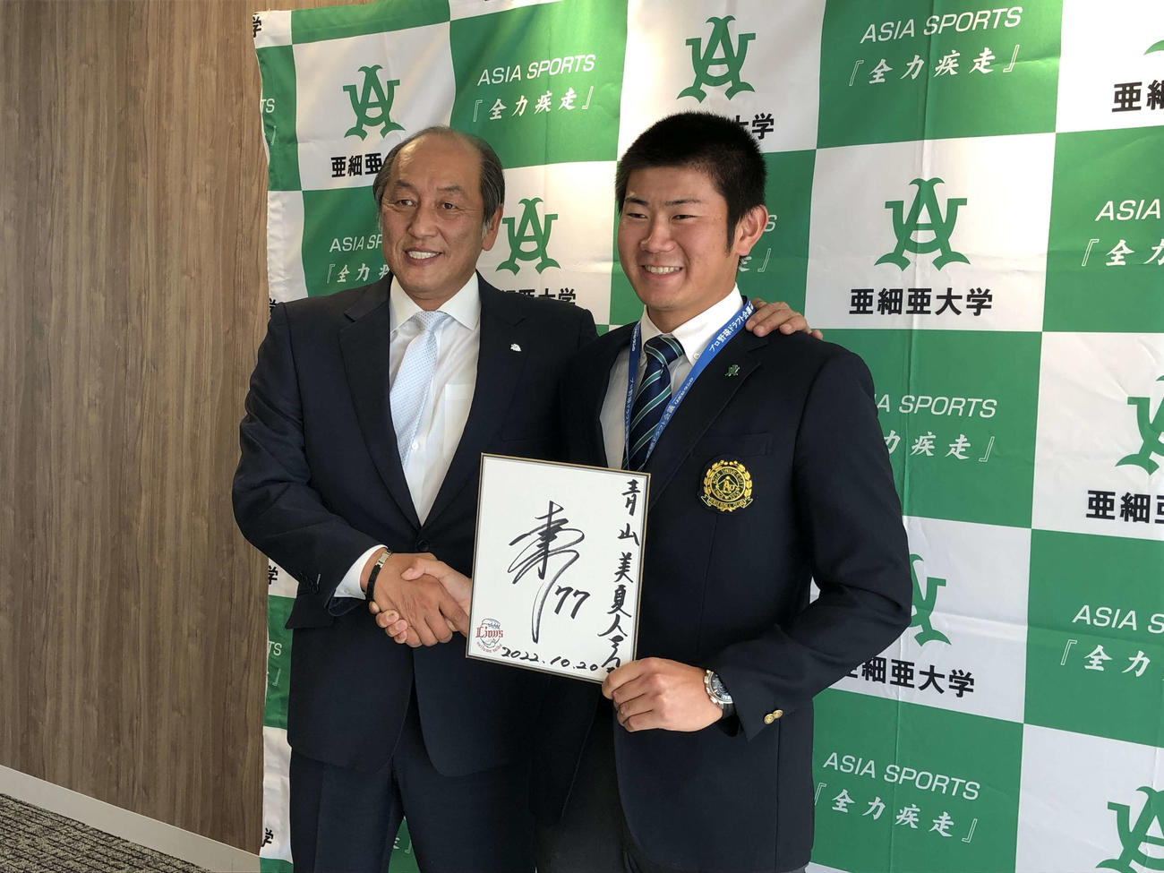 西武渡辺GM（左）と松井監督のサインを手に笑顔の亜大・青山（撮影・上田悠太）