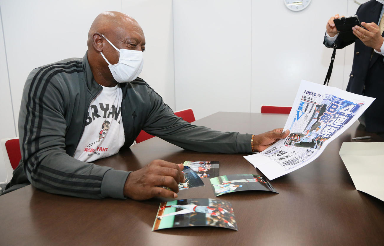 日本シリーズ・オリックス対ヤクルト戦観戦前に来社した、元近鉄のブライアント氏は、現役時代の写真を手に笑顔を見せる（撮影・宮崎幸一）