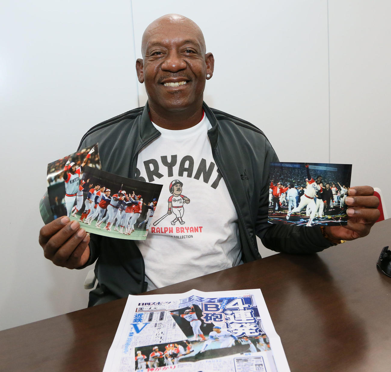 日本シリーズ・オリックス対ヤクルト戦観戦前に来社した、元近鉄のブライアント氏は、現役時代の写真を手に笑顔を見せる（撮影・宮崎幸一）