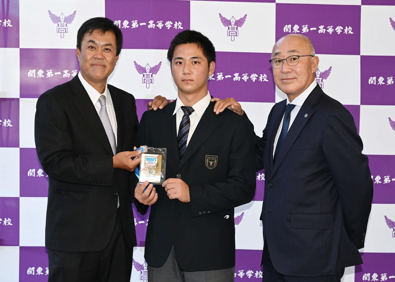 受け取った阪神岡田監督のサインが入ったドラフト会議のパスを手に記念撮影するドラフト3位の関東第一・井坪（中央）。左は平塚スカウトと畑山統括スカウト（撮影・滝沢徹郎）　
