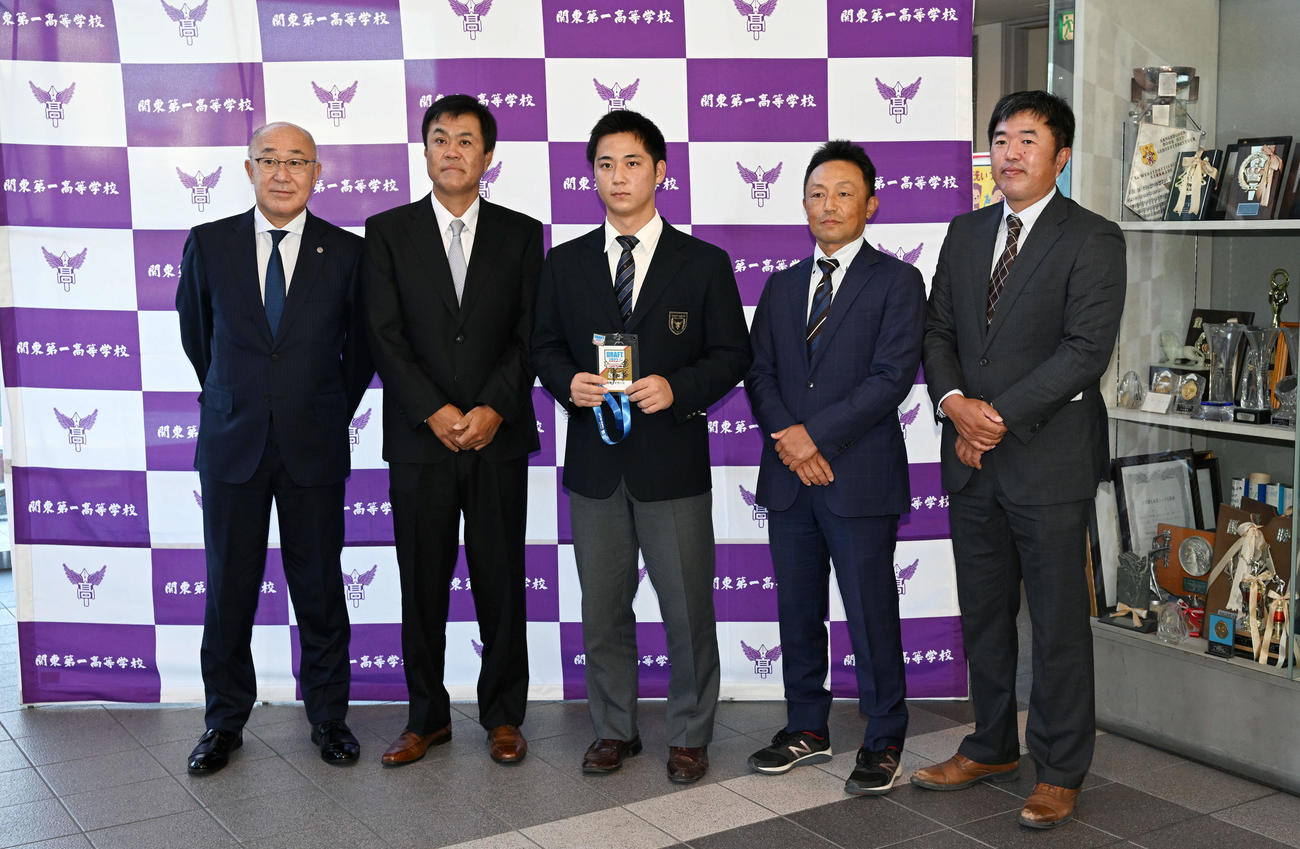 指名あいさつを受けた阪神ドラフト3位の関東第一・井坪（中央）は記念撮影する。左から畑山統括スカウト、平塚スカウト、1人おいて臼井部長、米沢監督（撮影・滝沢徹郎）　