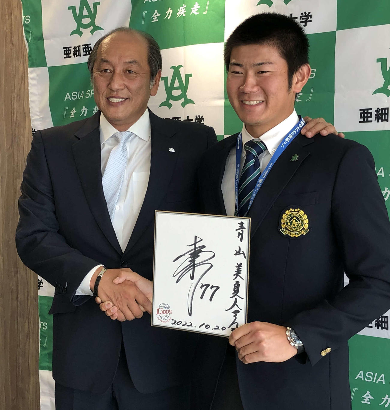 西武渡辺GM（左）と松井監督のサインを手に笑顔の亜大・青山（撮影・上田悠太）