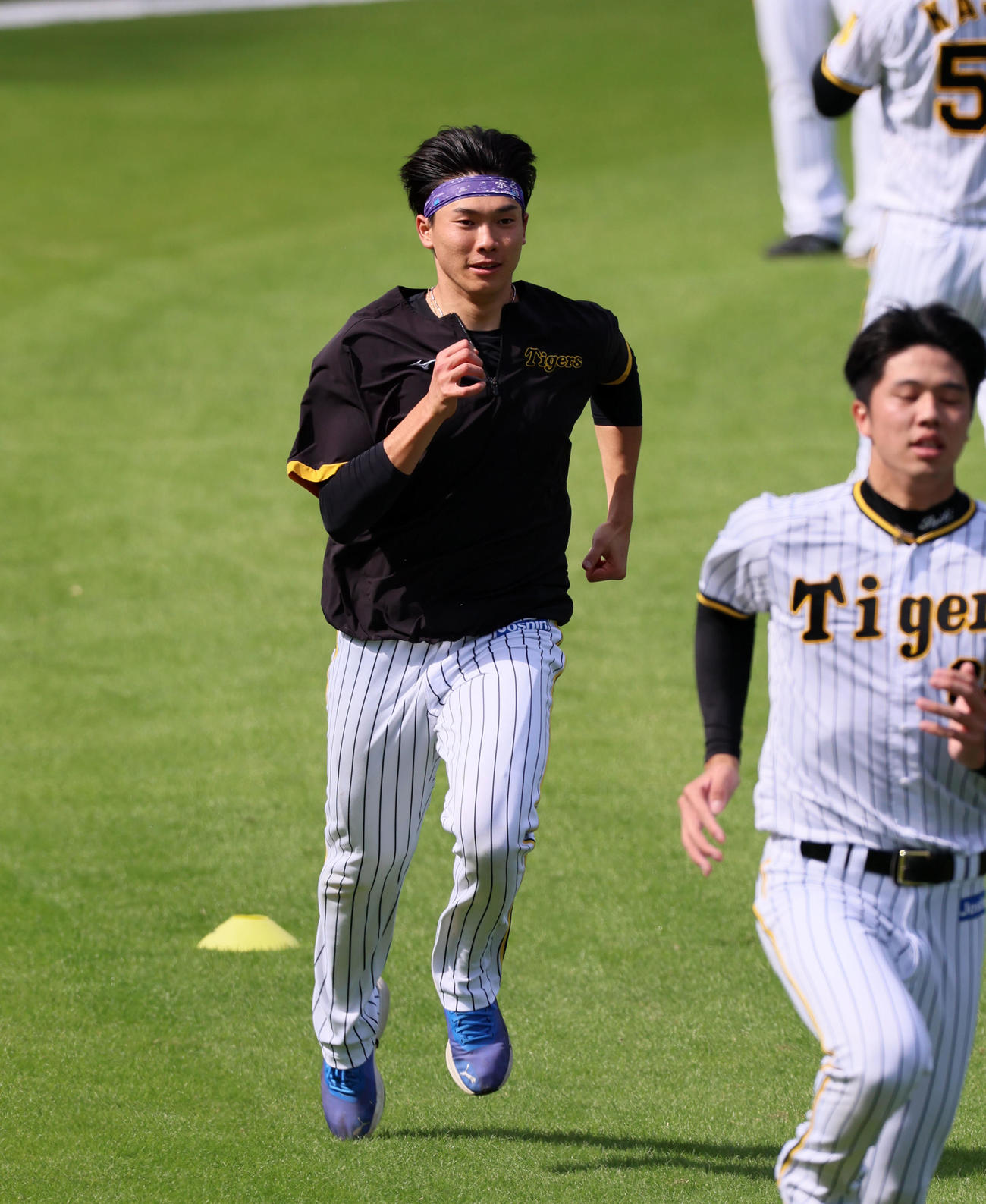 ブルペンに入ったあと外野でダッシュする湯浅。右は才木（撮影・加藤哉）