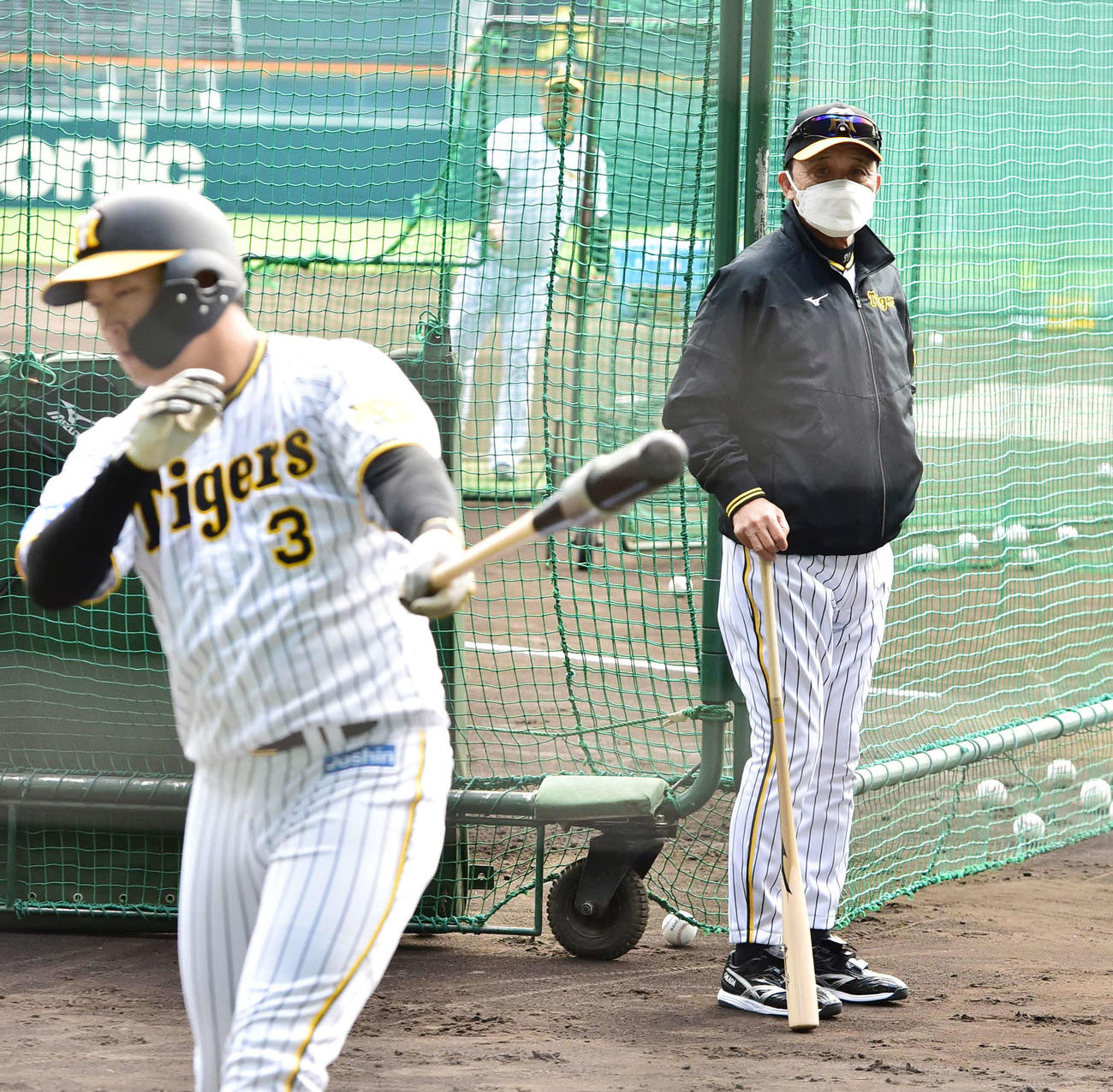 25日、阪神大山（手前）の打撃練習を見つめる岡田監督（撮影・清水貴仁）