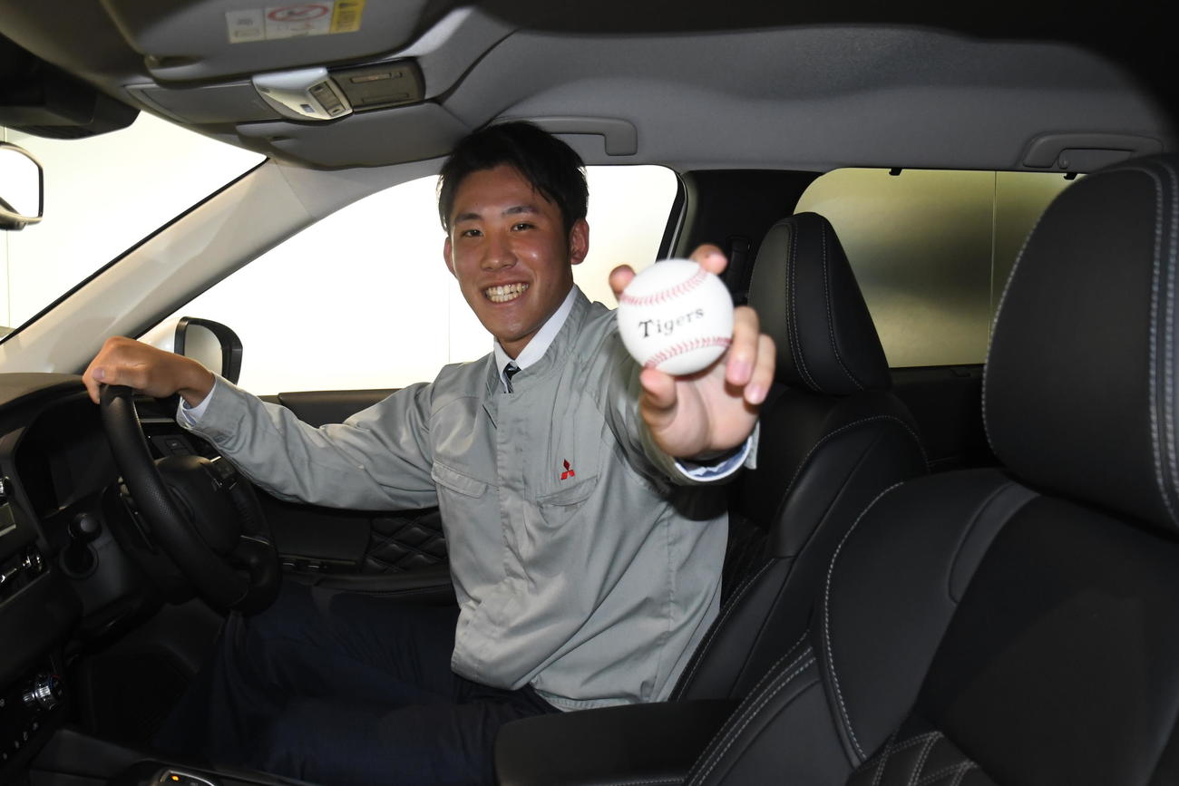 三菱製の自動車に乗り込み、笑顔で記念撮影する三菱自動車岡崎・富田蓮（撮影・中野椋）