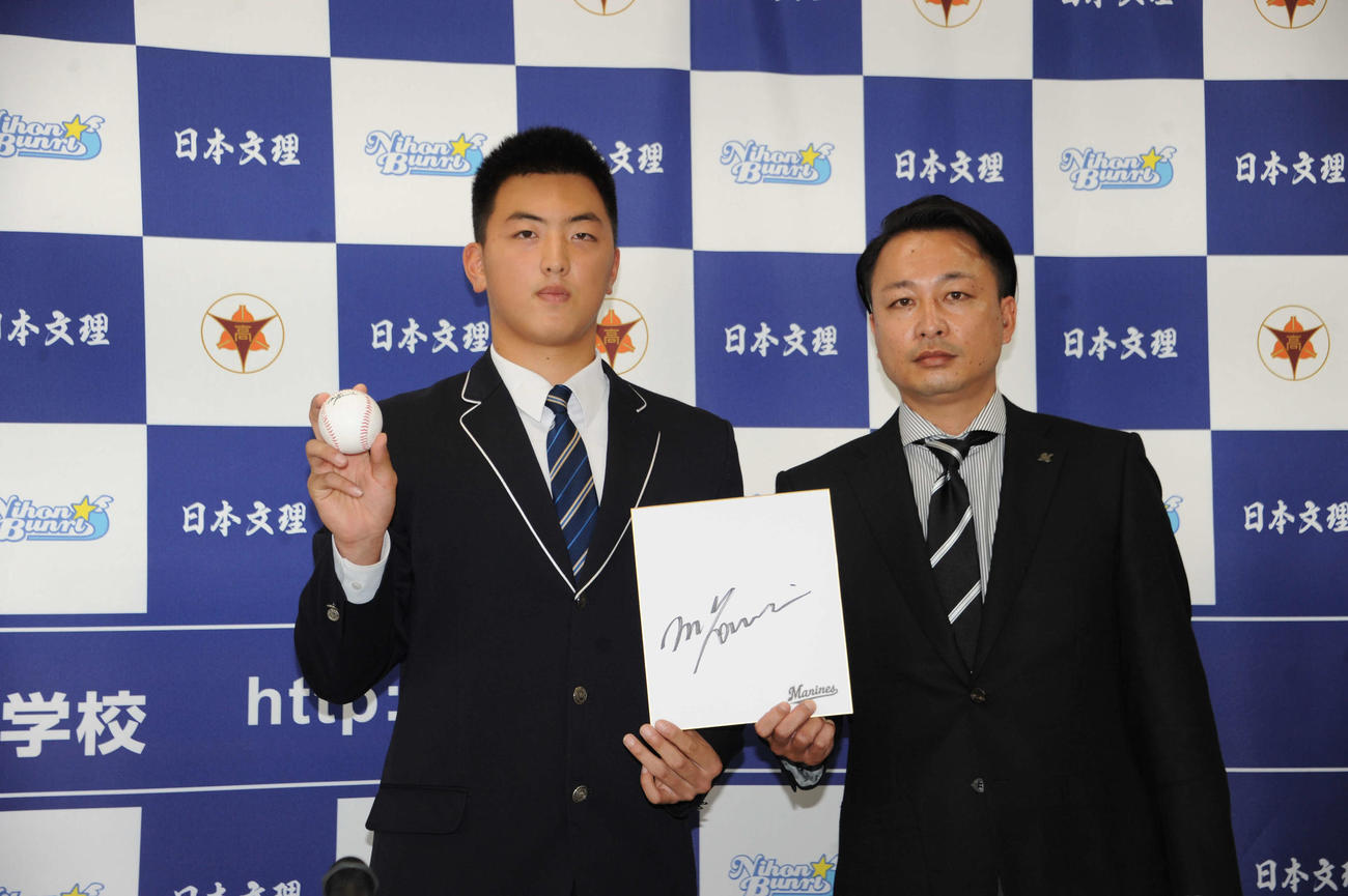 吉井監督のサイン入り色紙とサインボールを小林スカウトから手渡された日本文理・田中