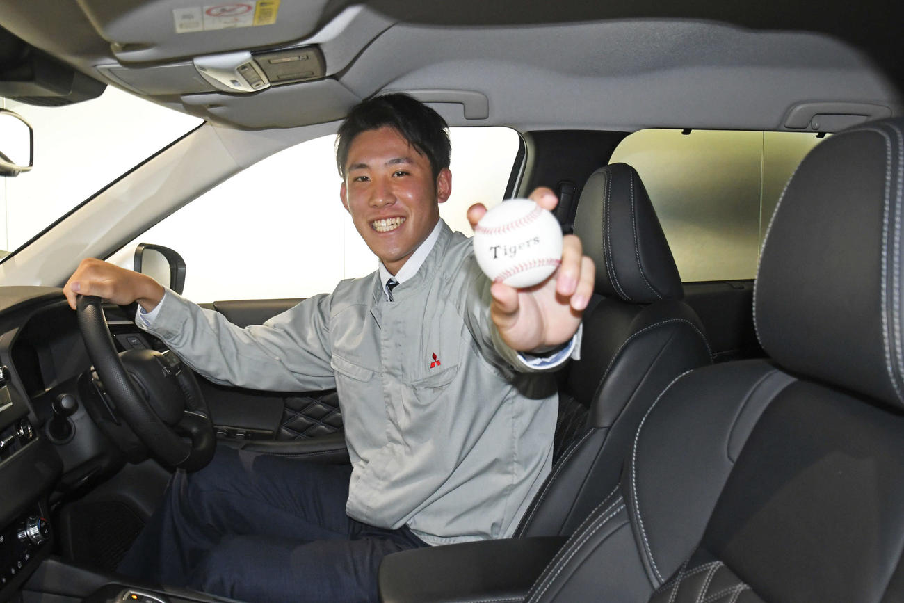 三菱製の自動車に乗り込み笑顔で記念撮影する三菱自動車岡崎・富田（撮影・中野椋）