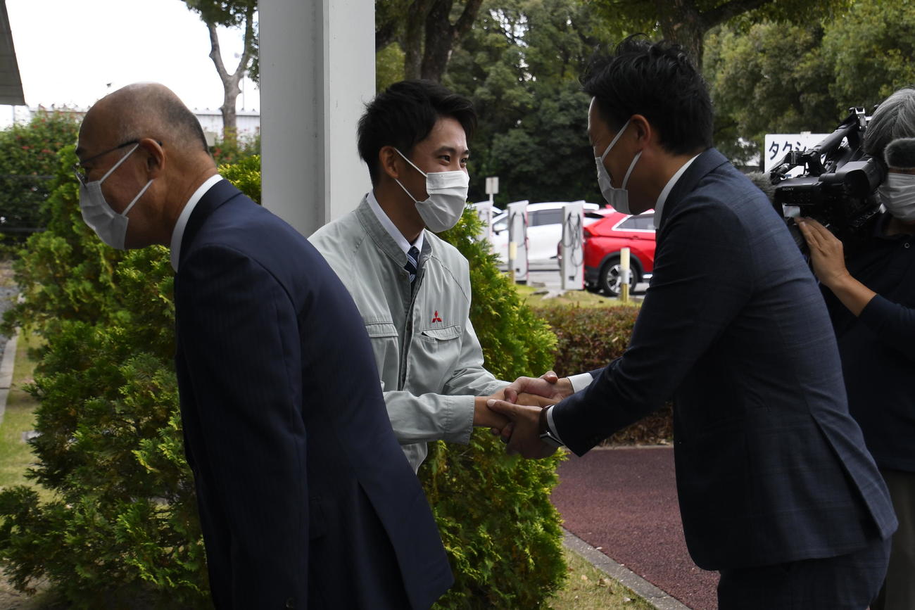 阪神筒井スカウト（右）と握手する阪神ドラフト6位の三菱自動車岡崎・富田蓮。左は畑山統括スカウト（撮影・中野椋）