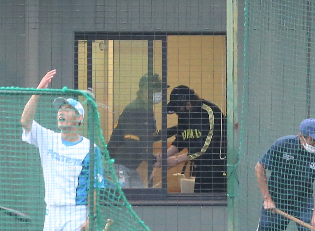 フェニックスリーグ　日本ハム対阪神　試合後の練習中、バックネット裏の部屋で握手する阪神和田2軍監督（左）と日本ハム新庄監督（撮影・黒川智章）