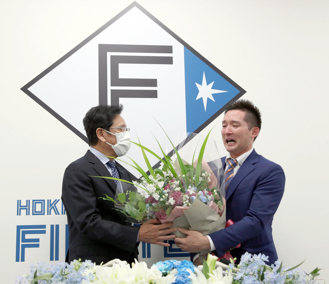 侍ジャパン栗山監督（左）から花束が贈られ涙する杉谷（撮影・佐藤翔太）