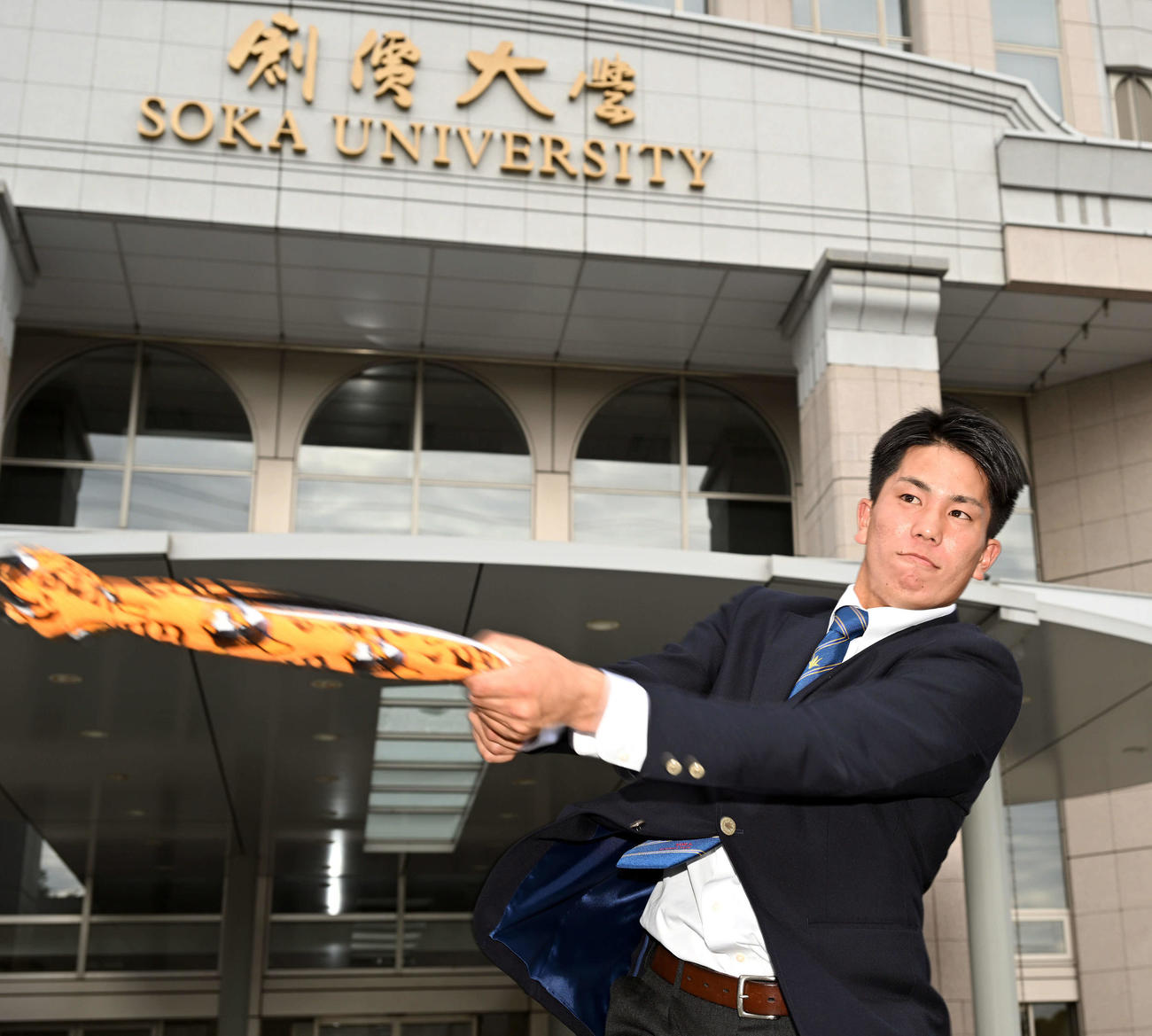 指名あいさつを受けた巨人ドラフト4位の創価大・門脇は巨人のタオルで素振りする（撮影・滝沢徹郎）