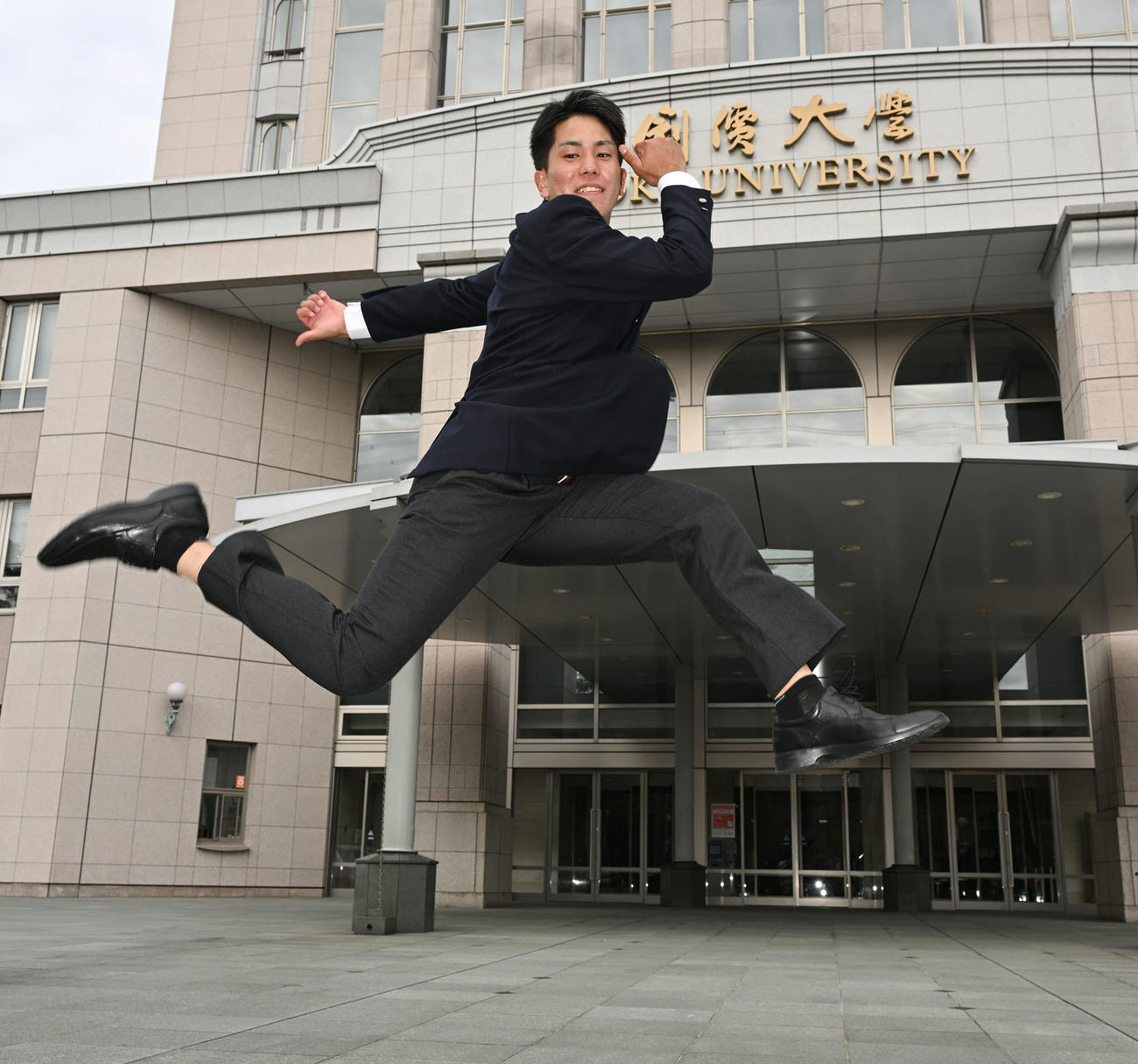 指名あいさつを受けた巨人ドラフト4位の創価大・門脇は大ジャンプする（撮影・滝沢徹郎）