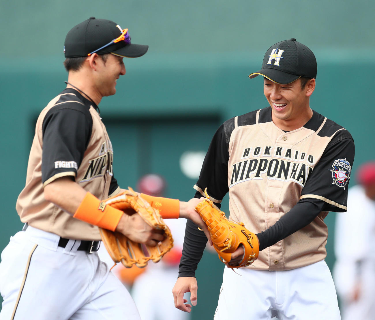 楽天対日本ハム　日本ハム先発の斎藤（右）は3回無安打の好投を見せ杉谷と笑顔でタッチ（2019年2月20日撮影）