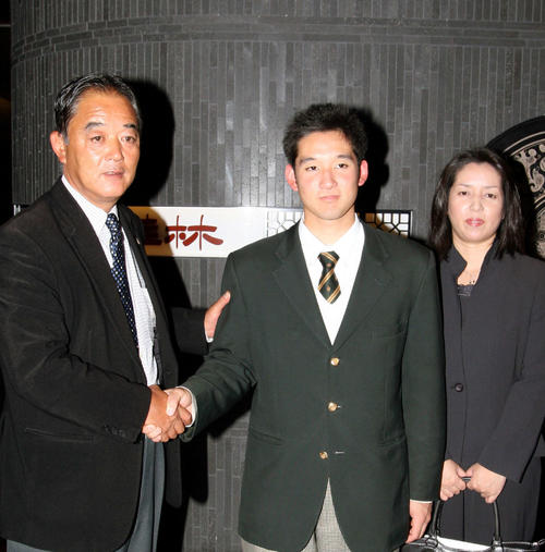 仮契約を済ませた杉谷拳士（中央）が今成スカウトと握手を交わす。右は杉谷の母真寿美さん