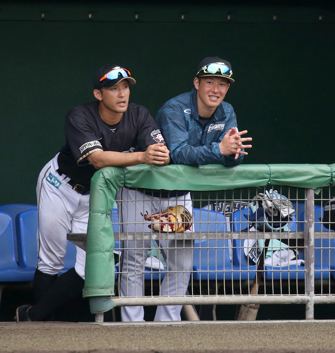 20年2月　紅白戦　ベンチで会話する日本ハム杉谷（左）と吉田輝