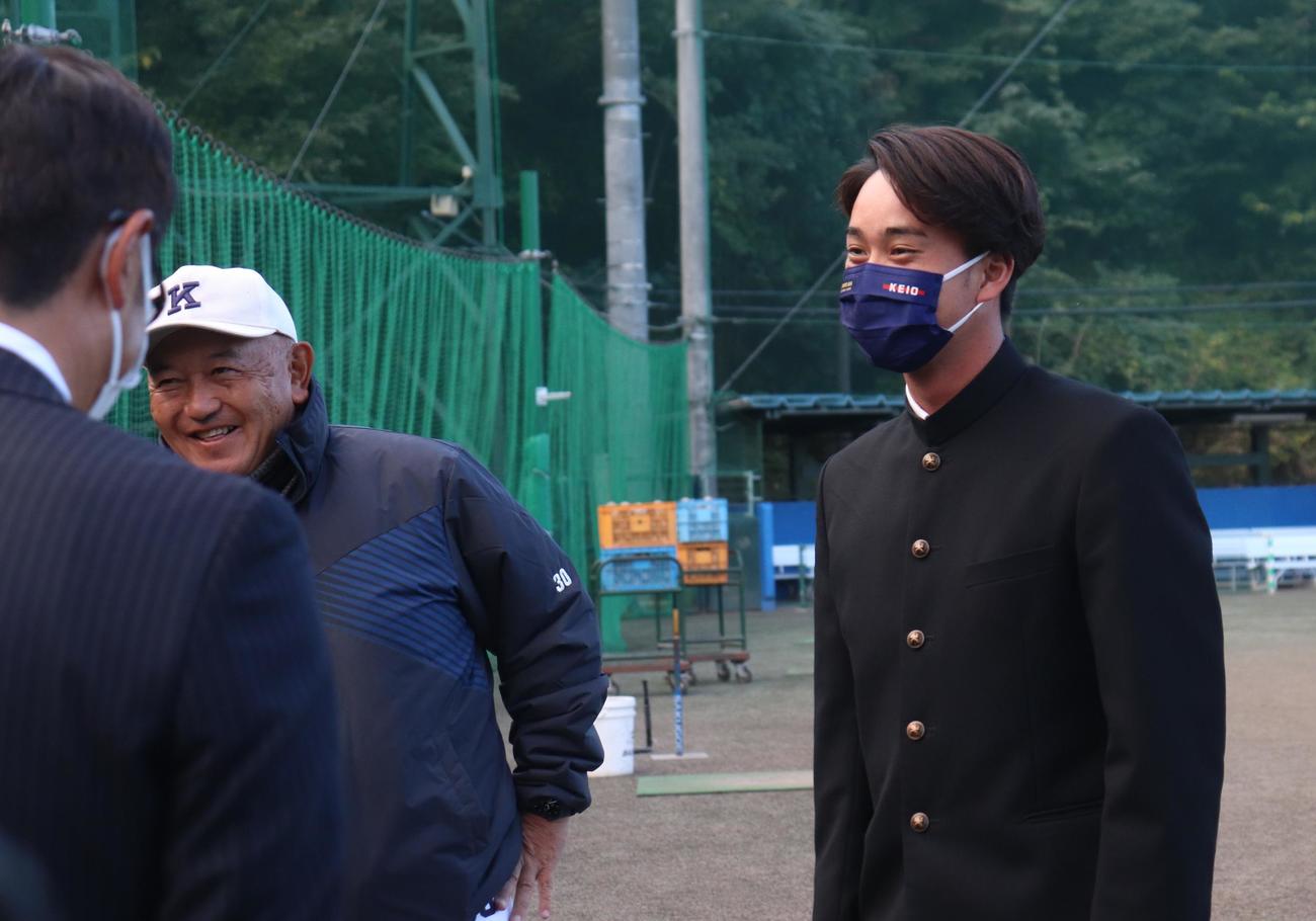 DeNAから指名あいさつを受けた慶大・橋本（右）は、堀井監督とともに笑顔をみせる（撮影・阿部泰斉）