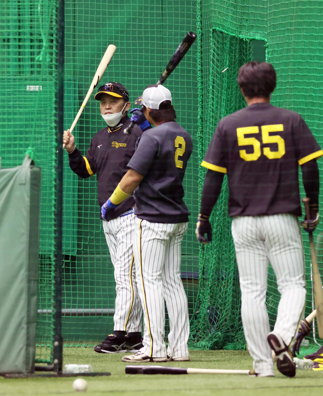 室内で打撃練習中の梅野（中）に声を掛ける岡田監督（撮影・加藤哉）