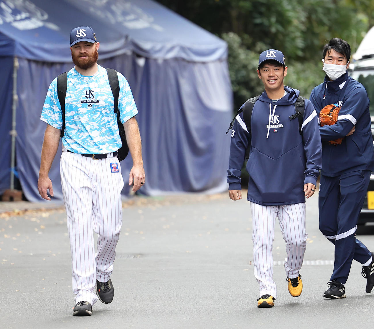 笑顔で練習場へ向かうヤクルトの小川（中央）とサイスニード（左）（撮影・足立雅史）