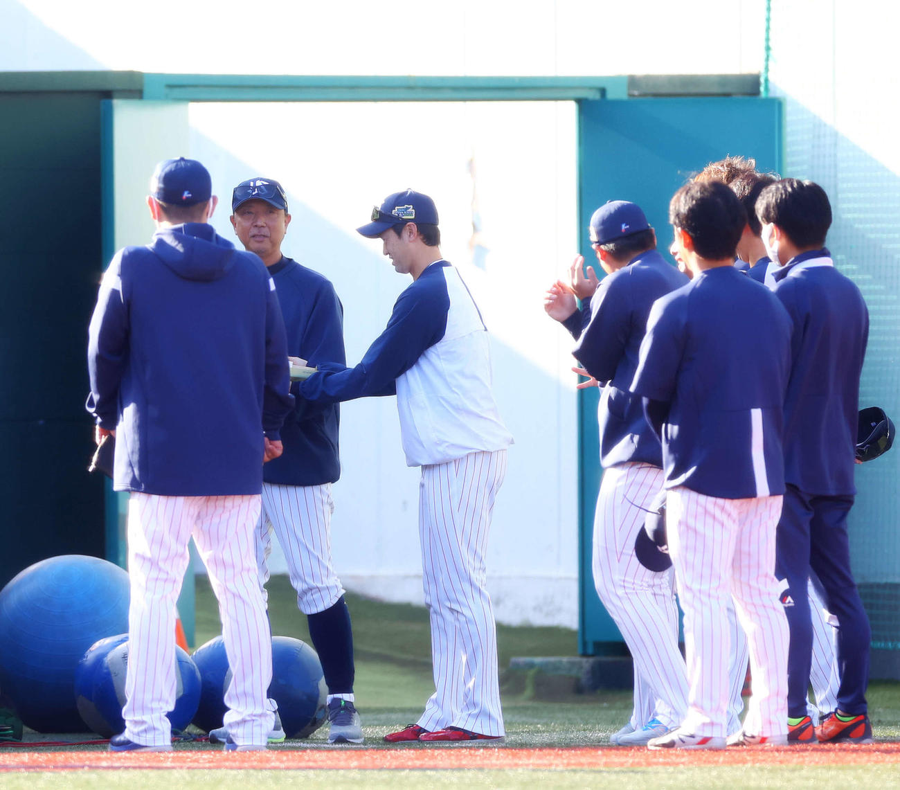 ヤクルト対オリックス　試合前、誕生日を迎え、石山（中央）から祝福されるヤクルト伊藤投手コーチ（左から2人目）（撮影・河田真司）