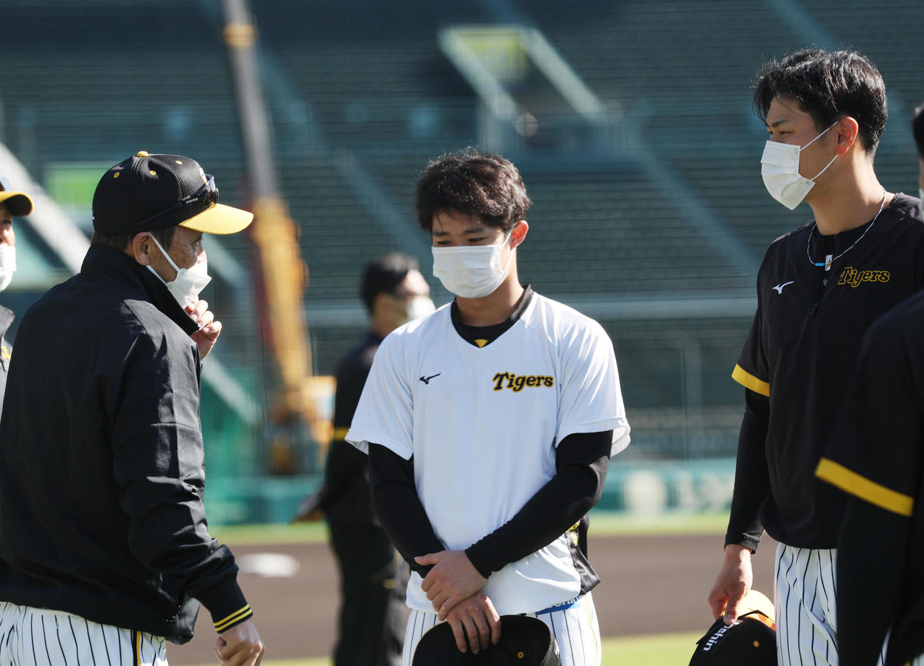 練習前に言葉を交わす、左から岡田監督、中野、佐藤輝（撮影・前田充）