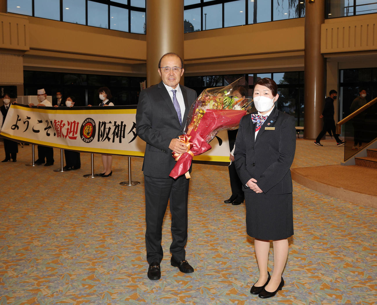 宿舎に到着しホテルから歓迎の花束を受け取った岡田監督（阪神球団提供）