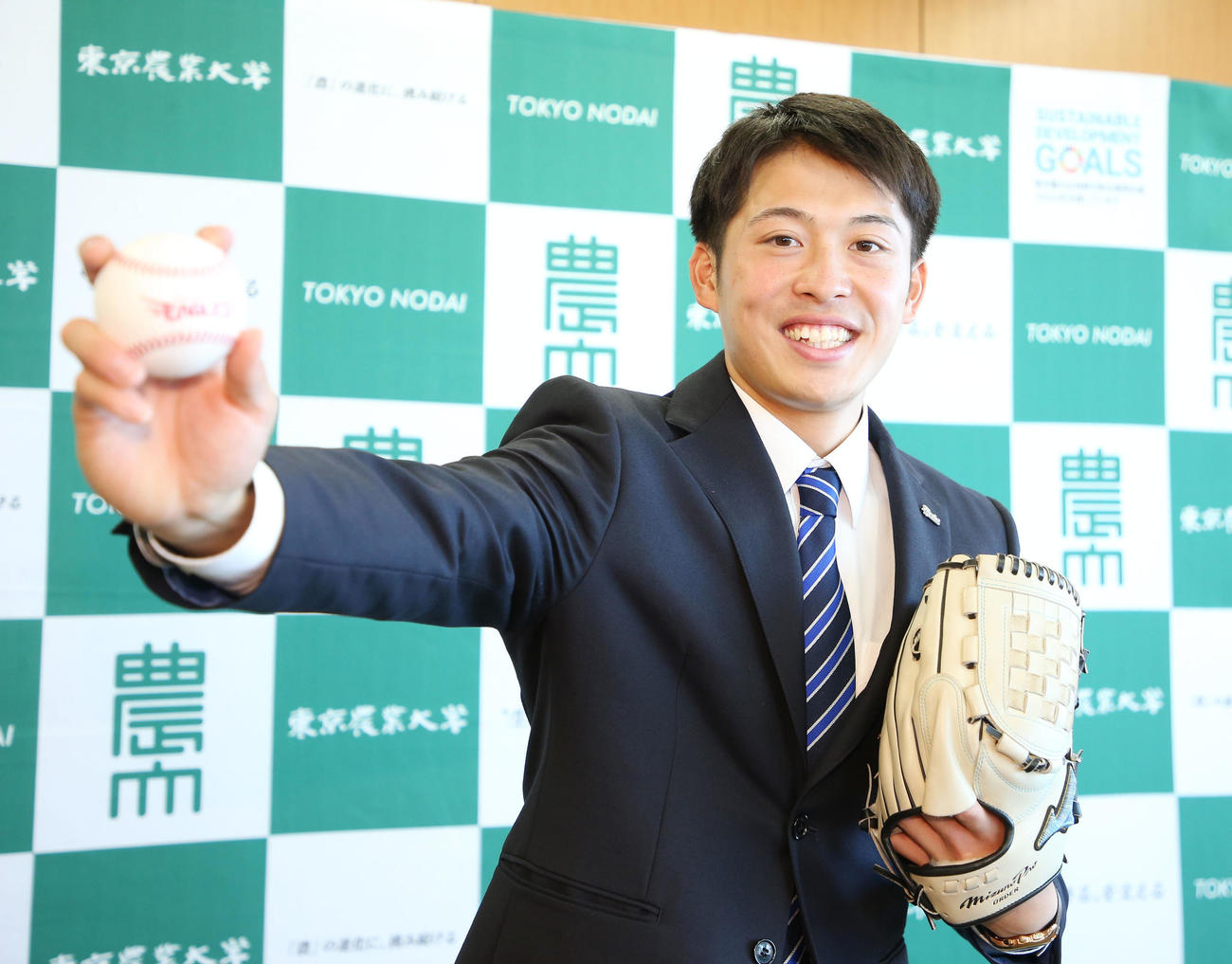 指名あいさつを受けた楽天ドラフト4位の東農大オホーツク・伊藤投手は笑顔で投球フォームを披露する（撮影・宮地輝）