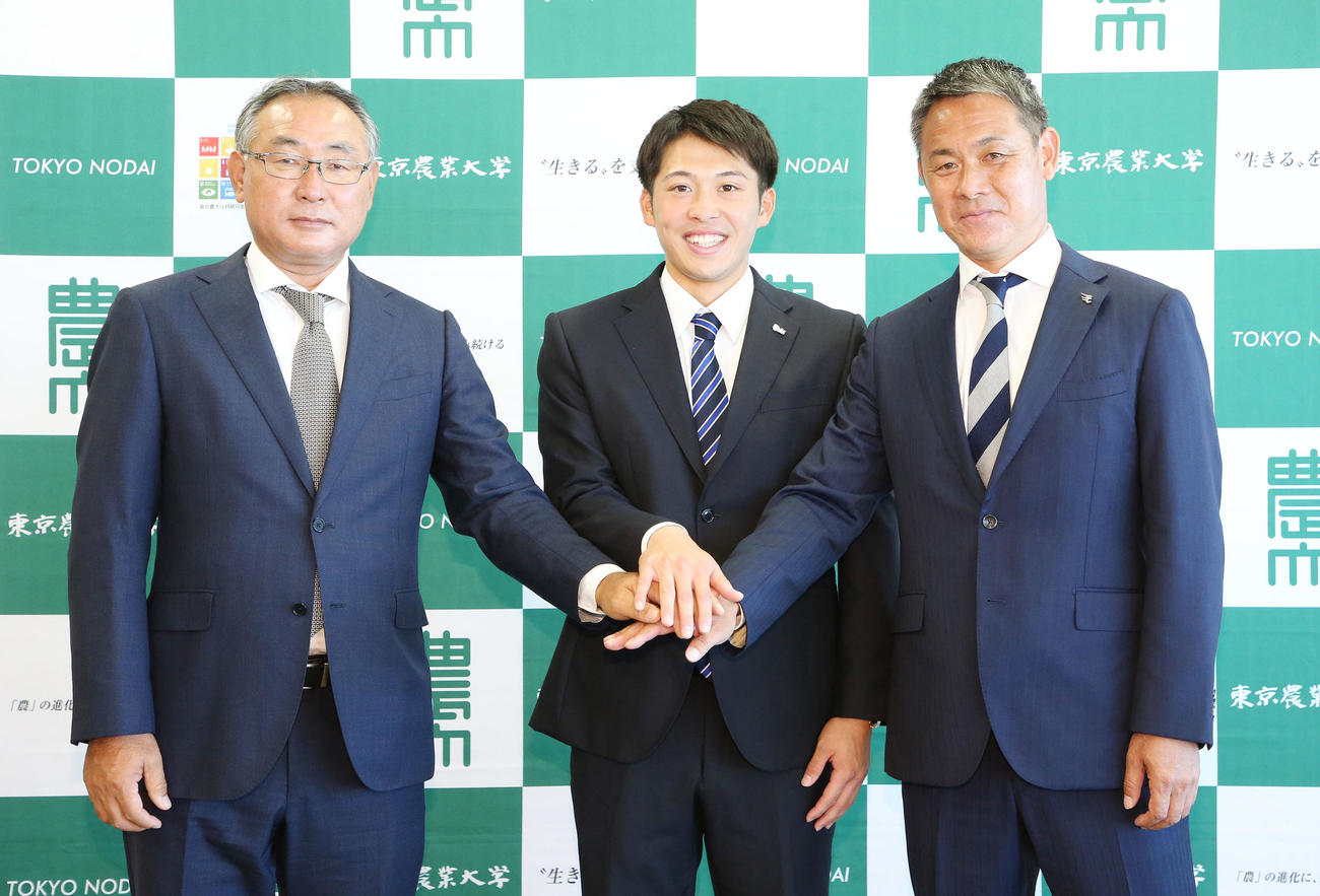 指名あいさつを受けた楽天ドラフト4位の東農大オホーツク・伊藤投手（中央）は後関スカウト部長（左）と益田スカウトと笑顔で手を合わす（撮影・宮地輝）