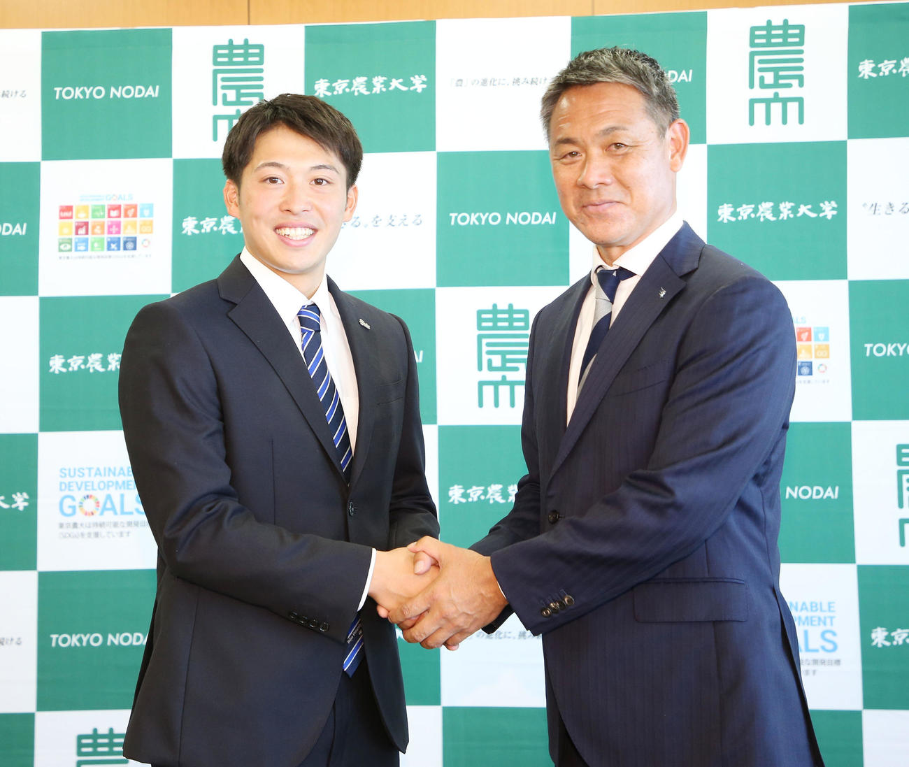 指名あいさつを受けた楽天ドラフト4位の東農大オホーツク・伊藤投手（左）は益田スカウトと笑顔で握手を交わす（撮影・宮地輝）