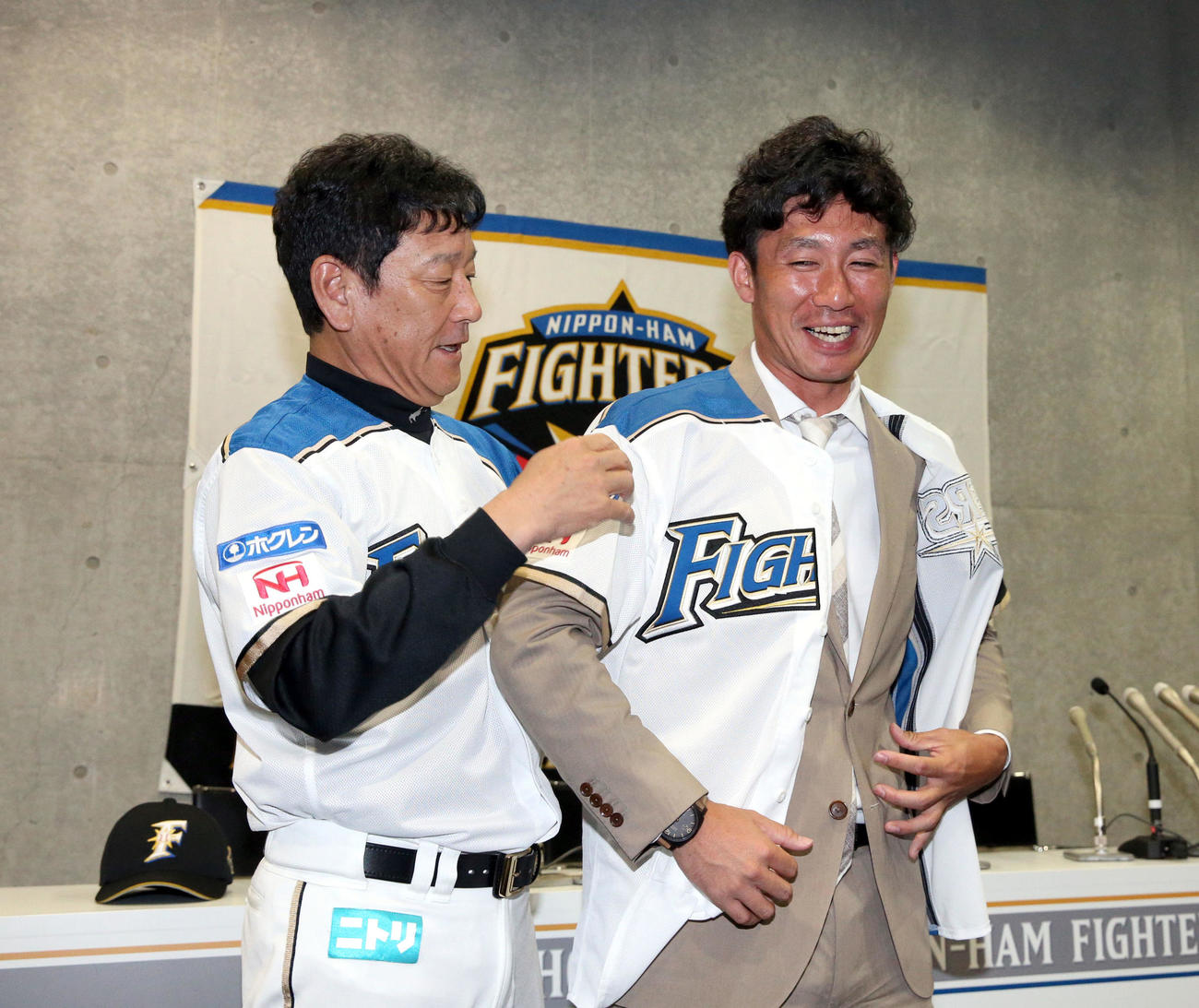 19年6月、日本ハム栗山監督にユニホームを着せてもらう吉川（右）