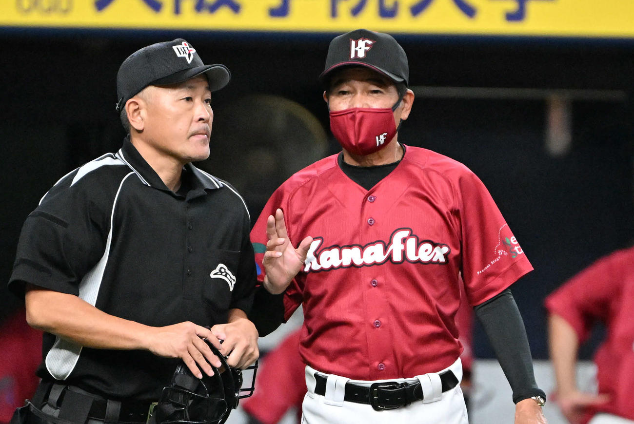 カナフレックス対日本通運　5回表終了後、北川審判(左)に選手交代を告げるカナフレックス・福間納監督(右)（撮影・石井愛子）