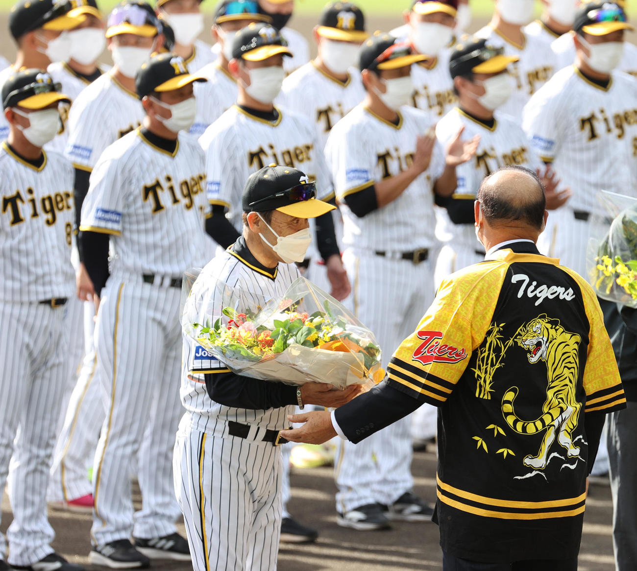 キャンプイン初日、歓迎セレモニーで花束を受け取る岡田監督（撮影・上山淳一）