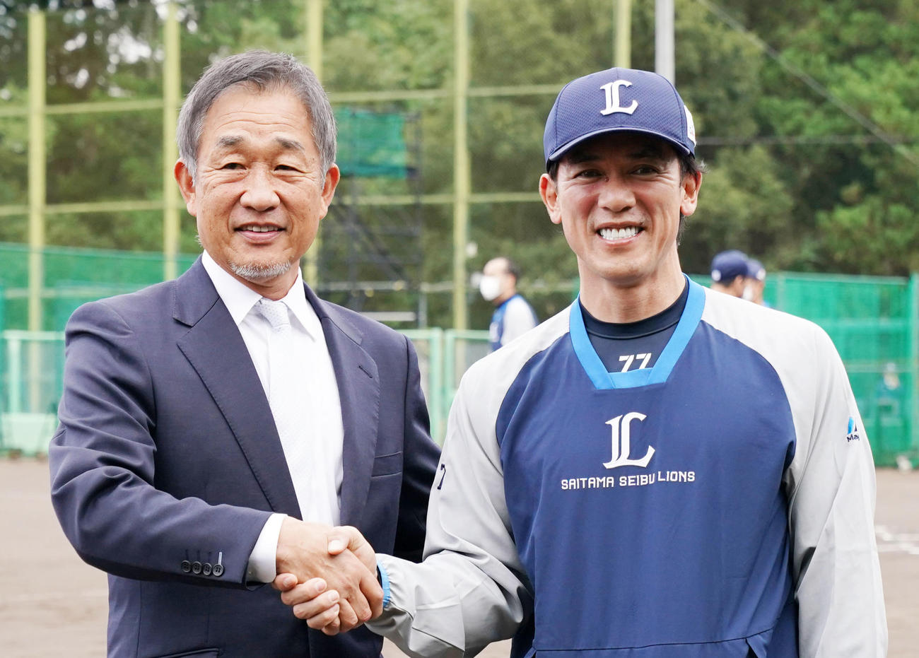 10月18日、笑顔で握手を交わす西武辻前監督（左）と松井新監督