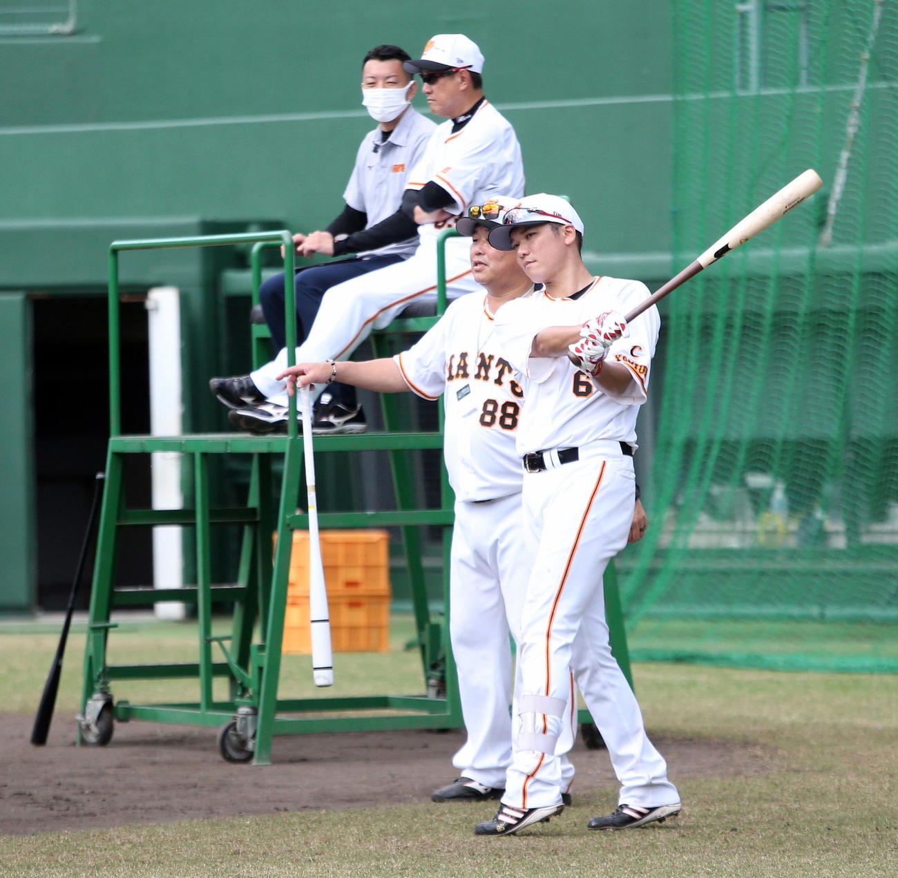 大久保1軍打撃チーフコーチの指導を受ける巨人坂本（右）。奥は原監督（撮影・三須一紀）