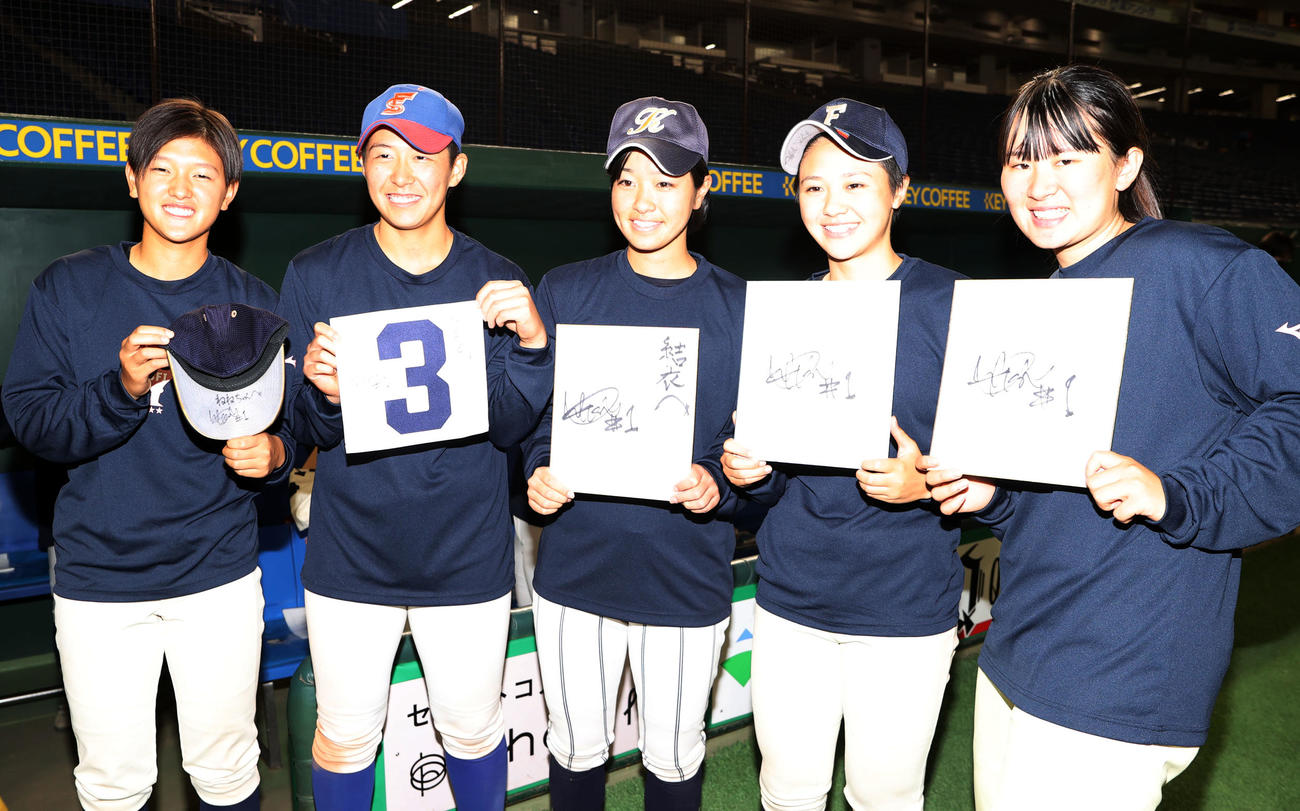 イチロー選抜対高校野球女子選抜　試合後、イチロー氏からもらったサインを手に笑顔を見せる高校野球女子選抜の選手たち（撮影・狩俣裕三）