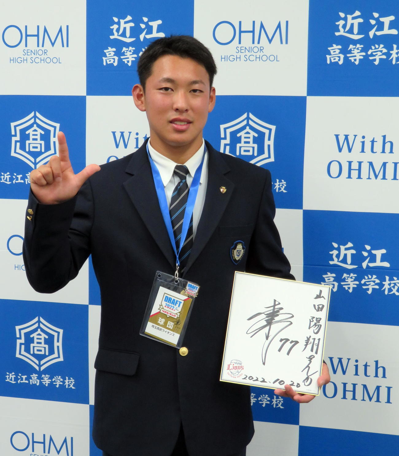 西武ドラフト5位の指名あいさつで松井監督のサイン色紙とドラフト会議のパスをプレゼントされてライオンズの「Lポーズ」で笑顔をみせる近江・山田（撮影・鎌田直秀）